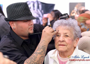 Wiser Oner face painting an older lady